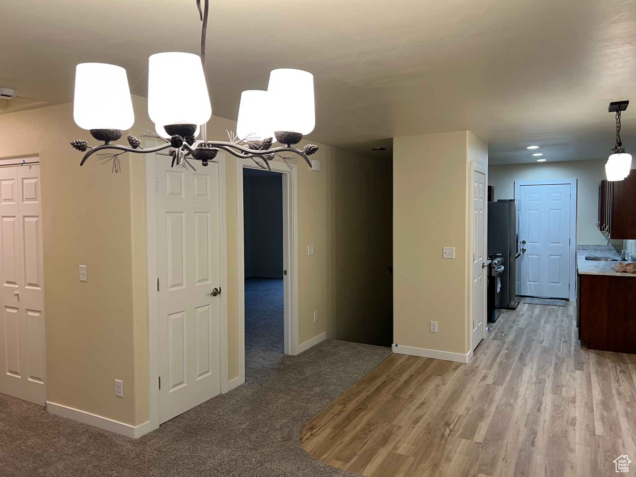 Unfurnished dining area with light hardwood / wood-style flooring and a notable chandelier