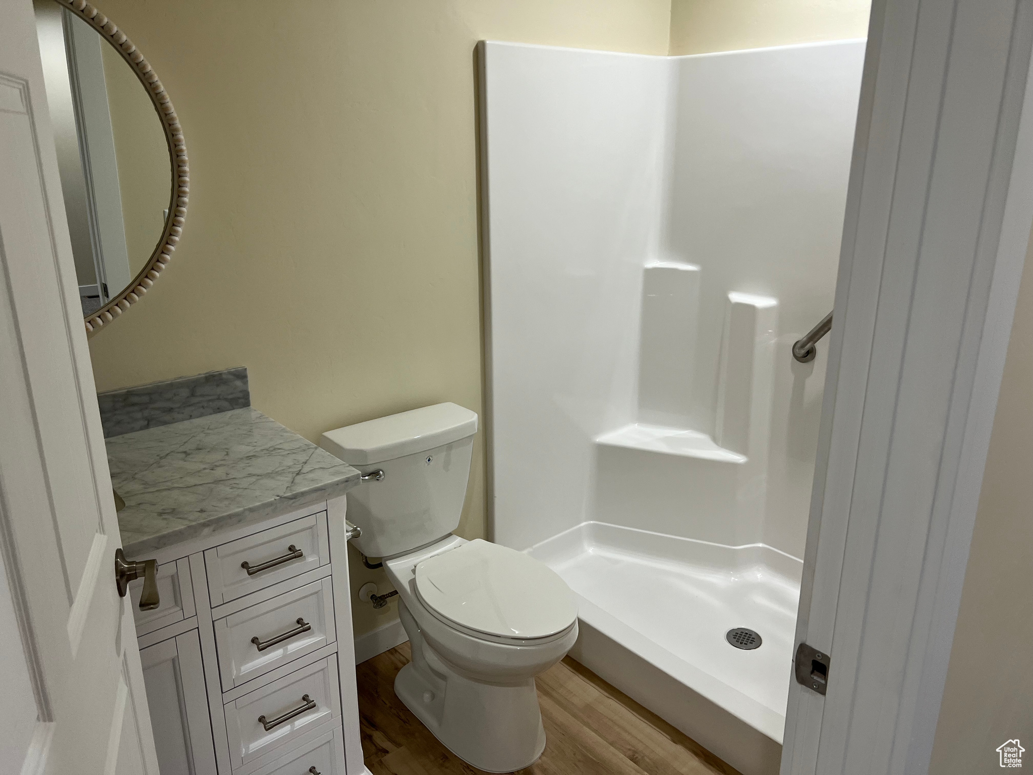 Bathroom with vanity, toilet, walk in shower, and hardwood / wood-style floors