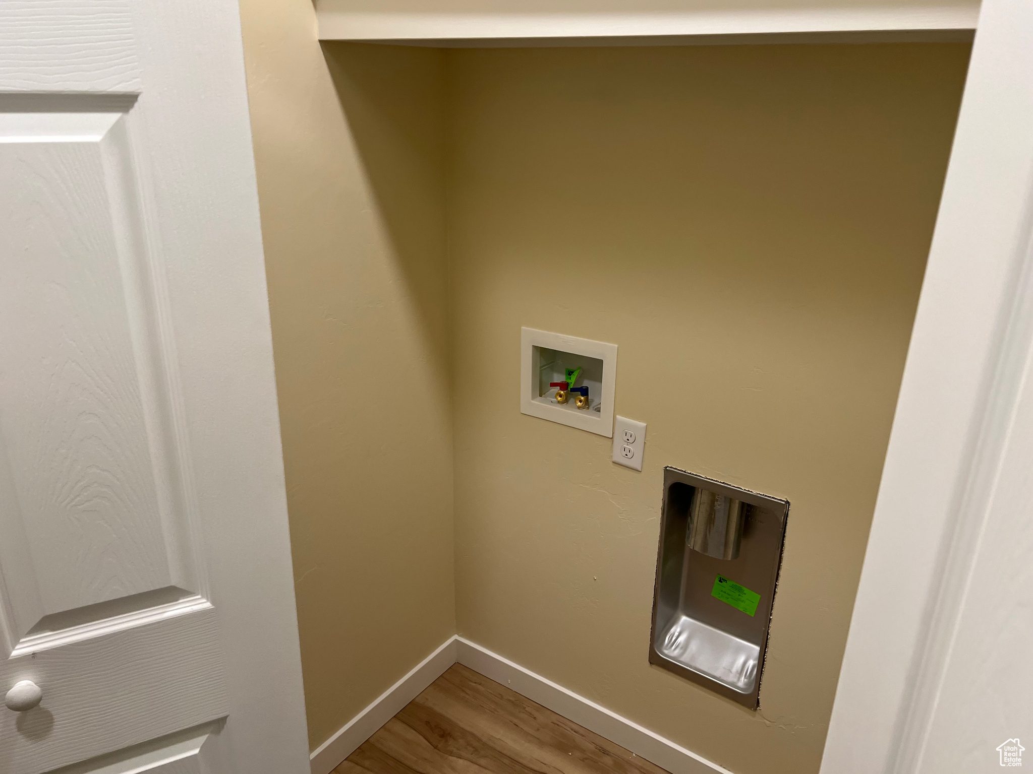 Clothes washing area with hardwood / wood-style floors and washer hookup