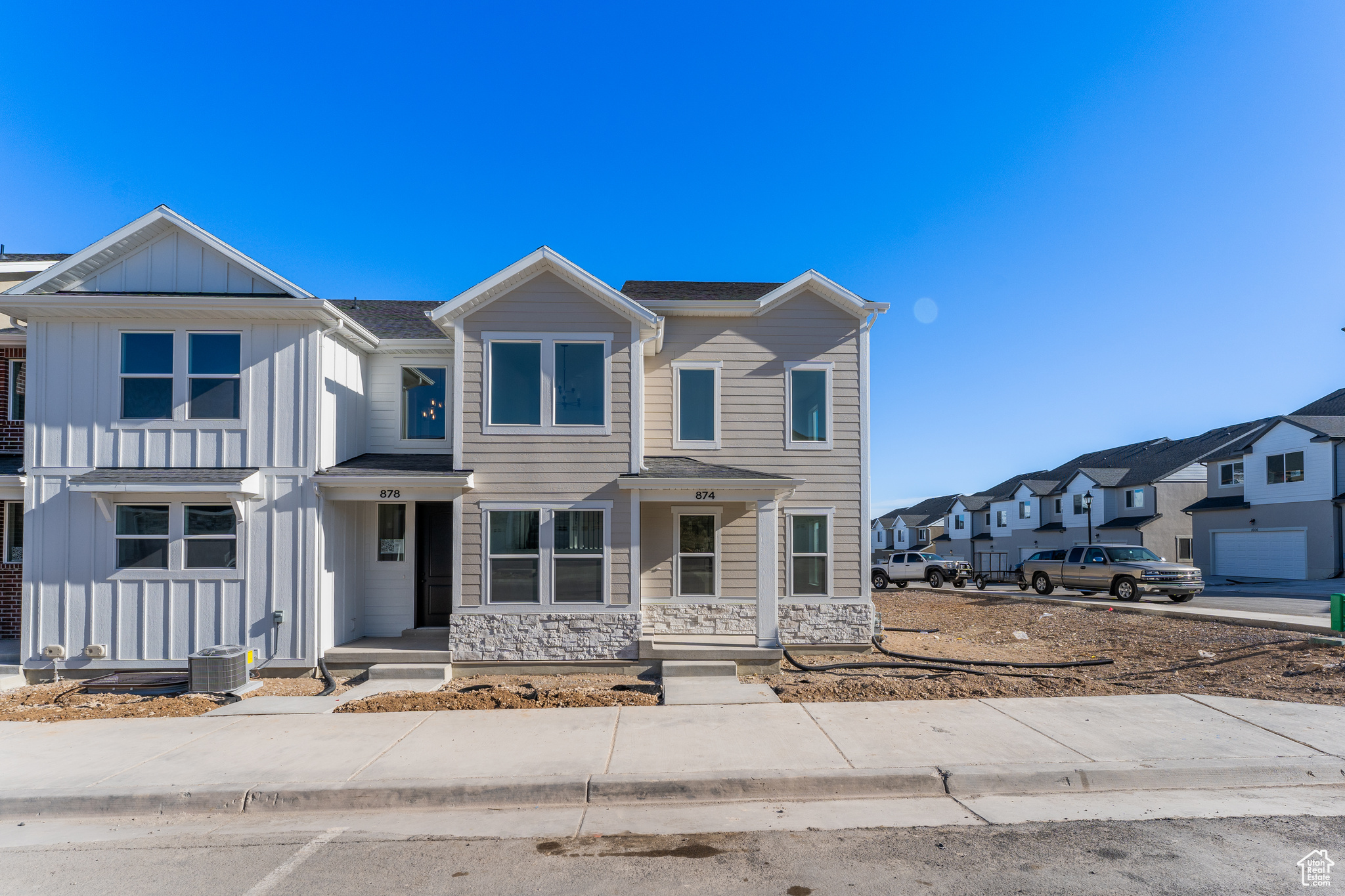 Multi unit property with a residential view, stone siding, board and batten siding, and central AC