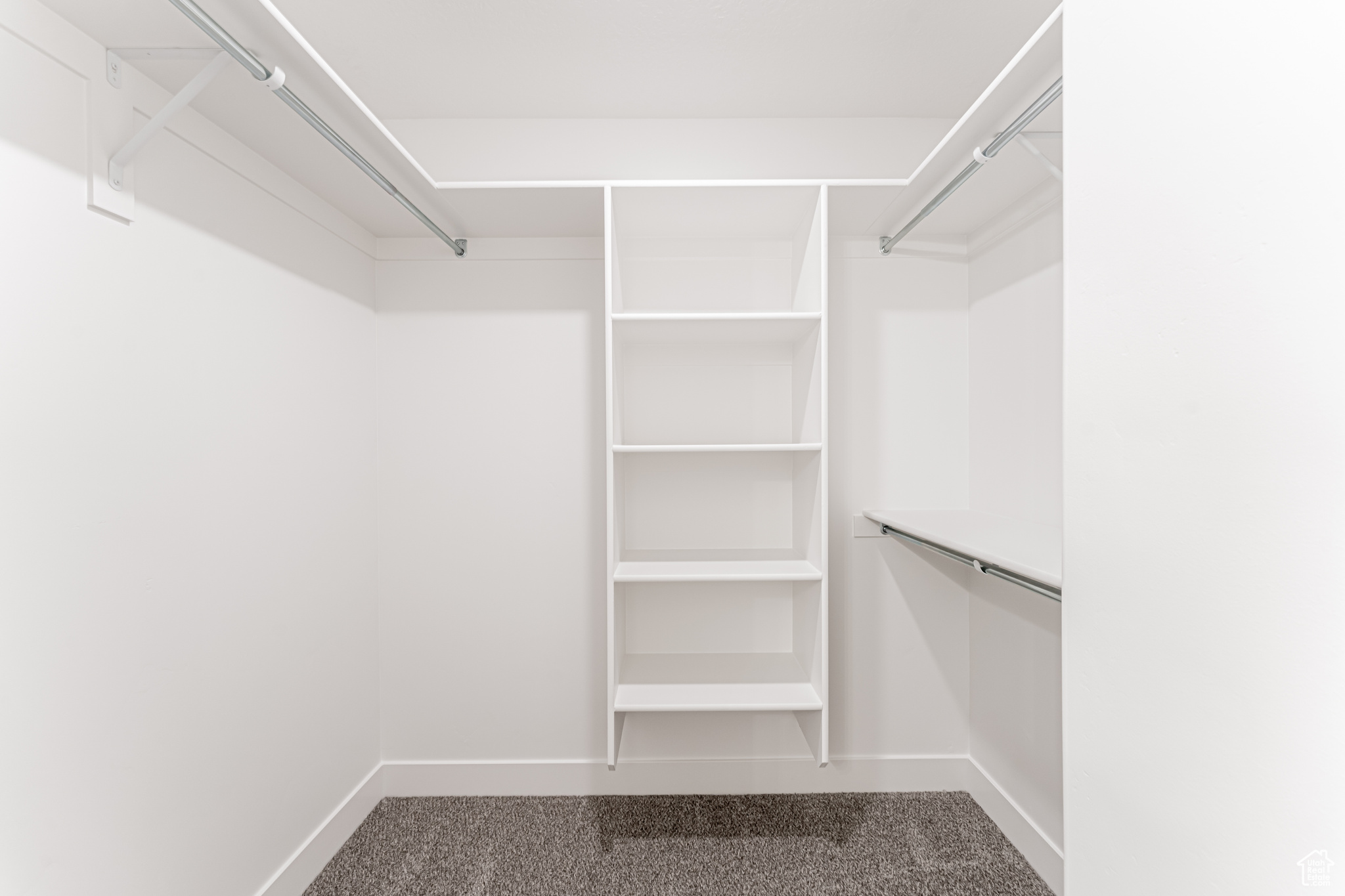 Walk in closet with dark carpet