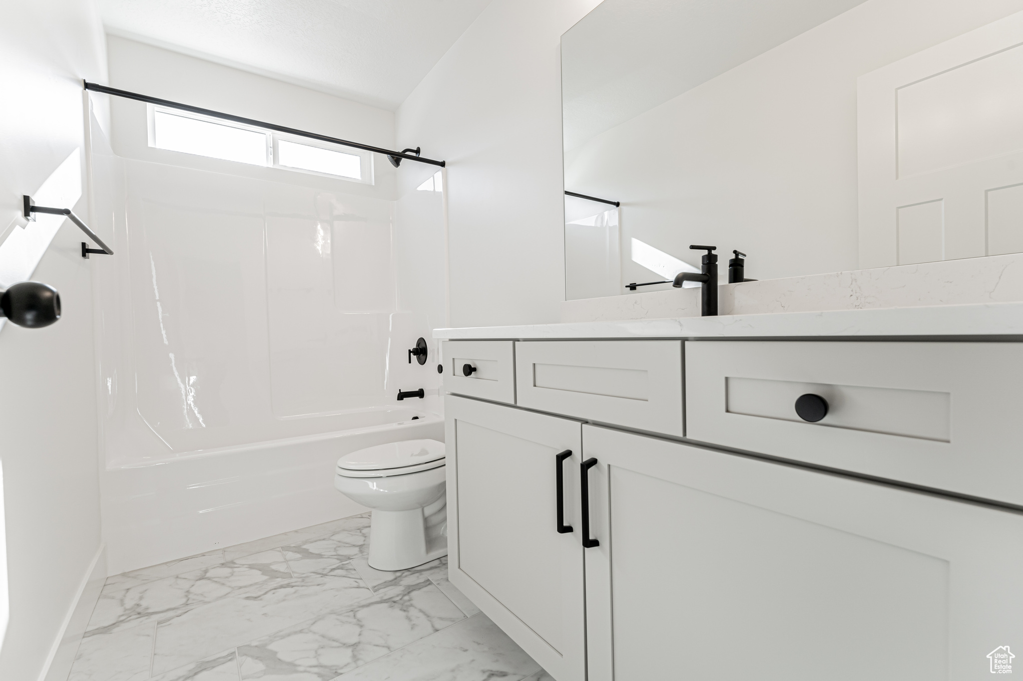 Full bathroom featuring shower / bath combination, toilet, marble finish floor, and vanity