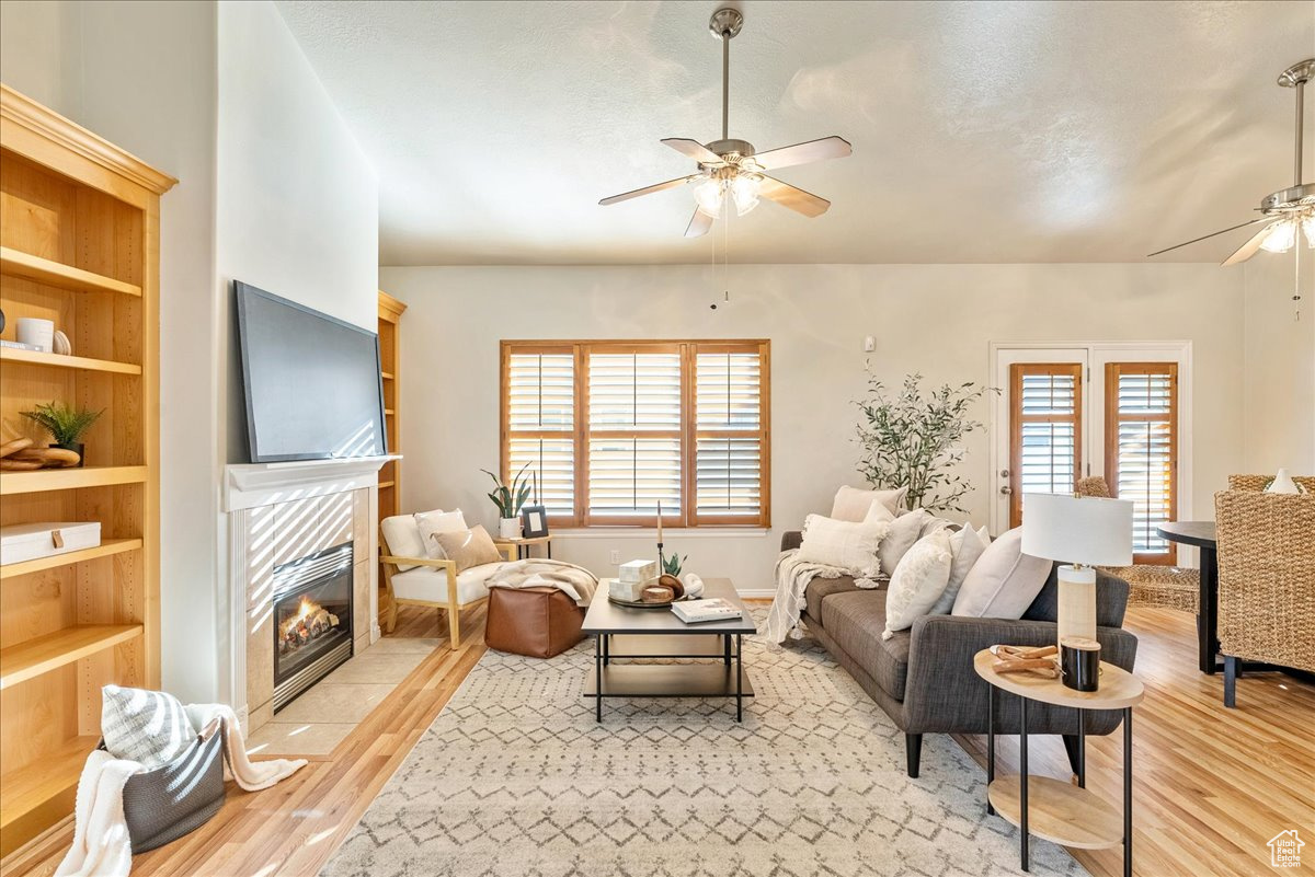 Living room with light hardwood / wood-style floors, a fireplace, and ceiling fan