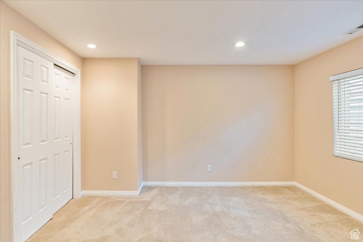 Interior space with light colored carpet and a closet