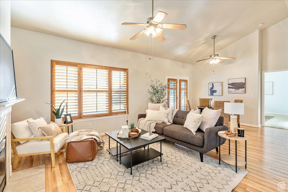 Living room featuring lofted ceiling, light hardwood / wood-style floors, and ceiling fan