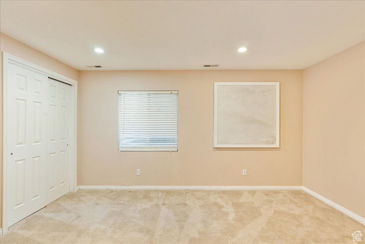 Unfurnished bedroom with a closet and light colored carpet