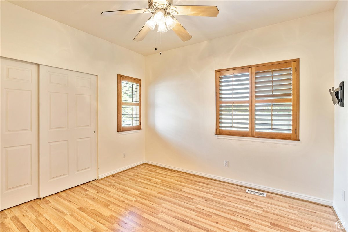 Unfurnished bedroom featuring a closet, ceiling fan, and light wood-type flooring