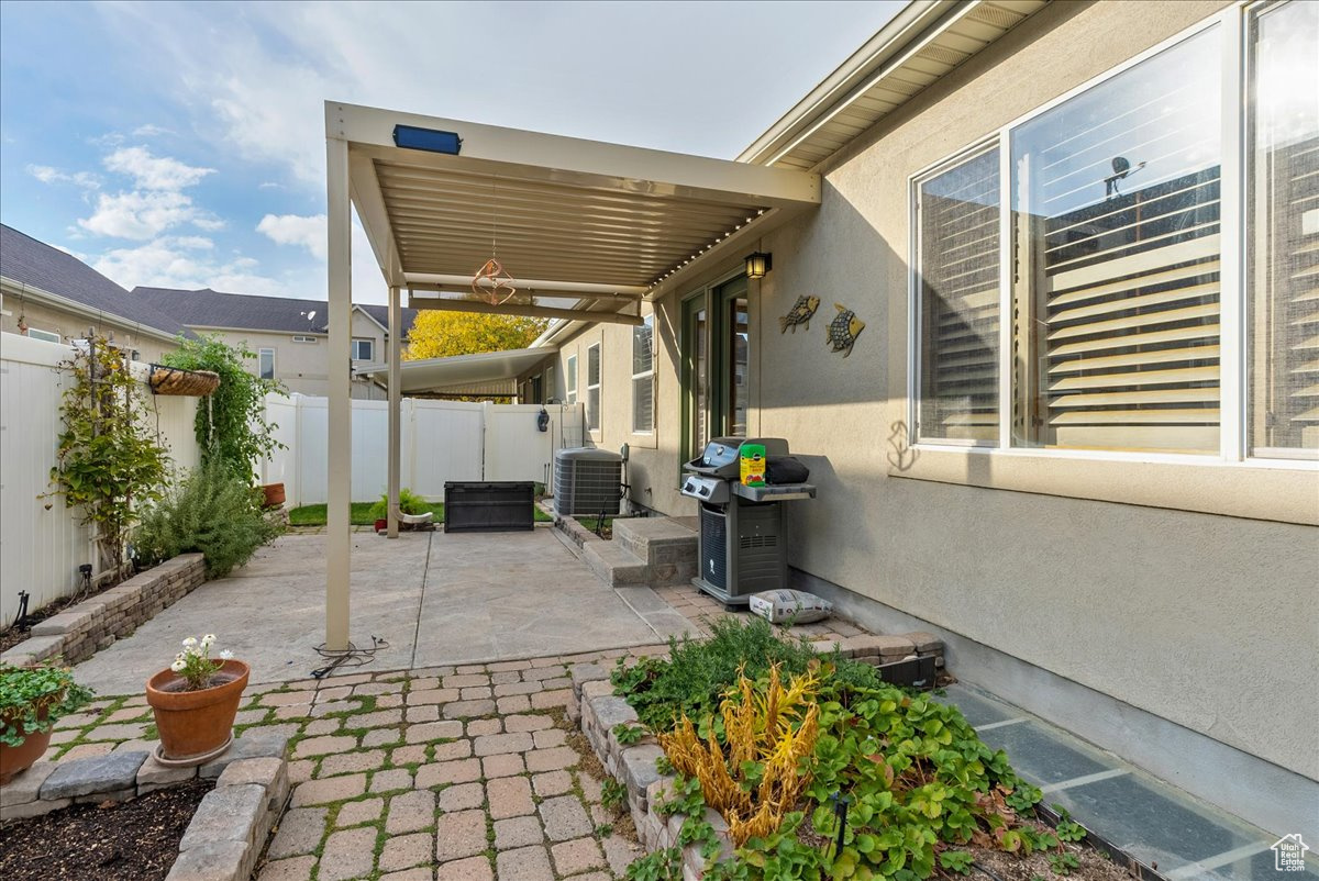 View of patio featuring cooling unit and area for grilling