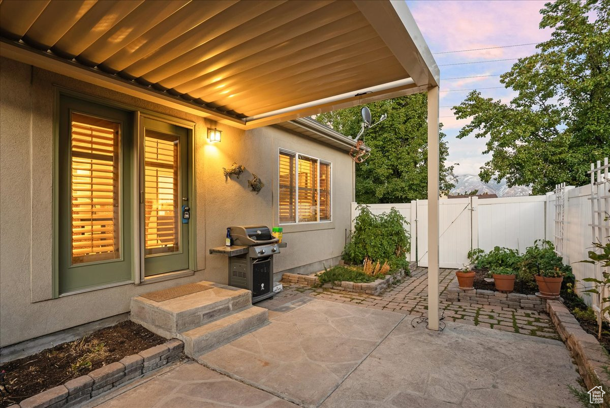 Patio terrace at dusk featuring a grill