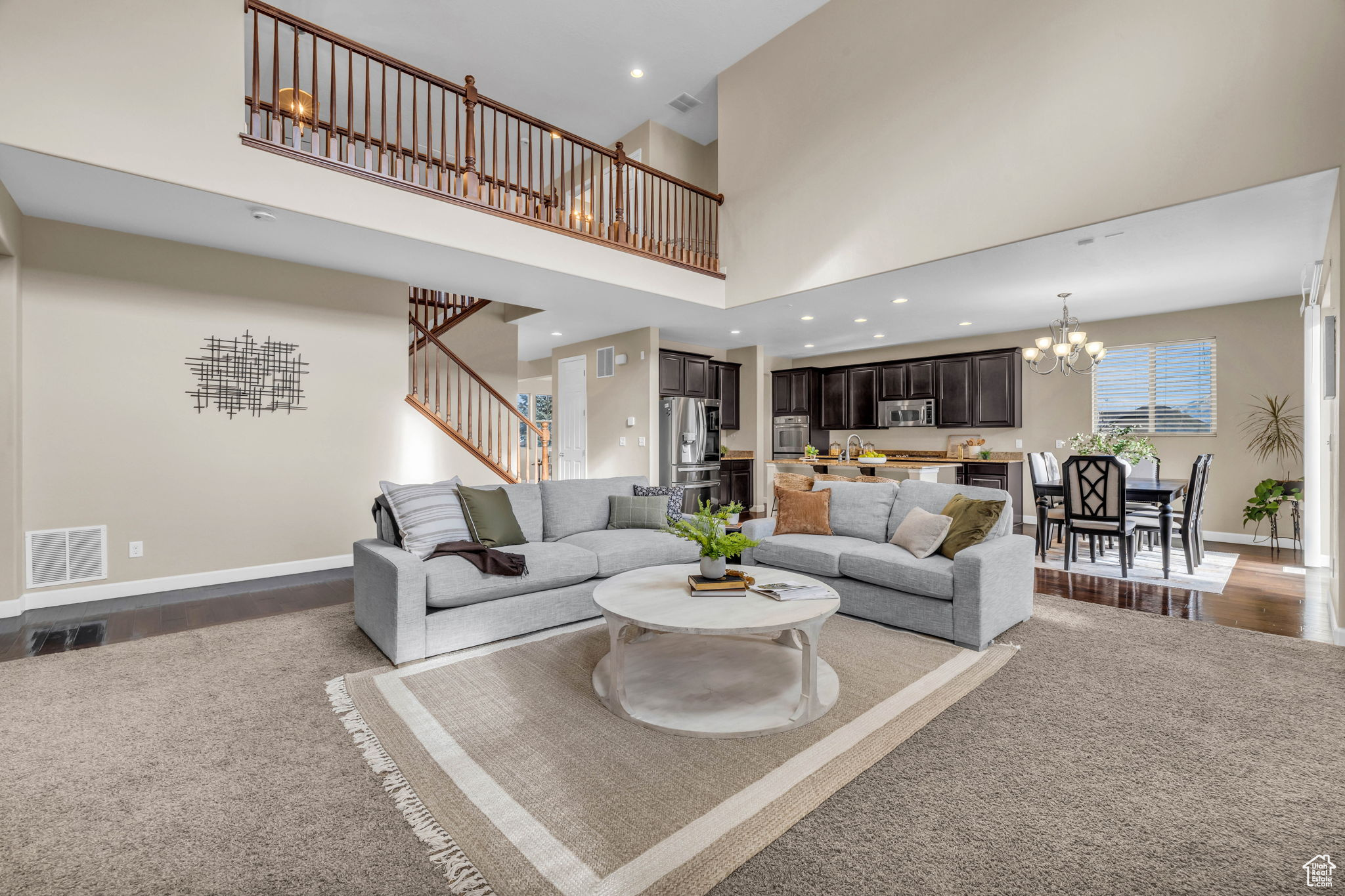 Living room with a chandelier, a high ceiling, and hardwood / wood-style flooring