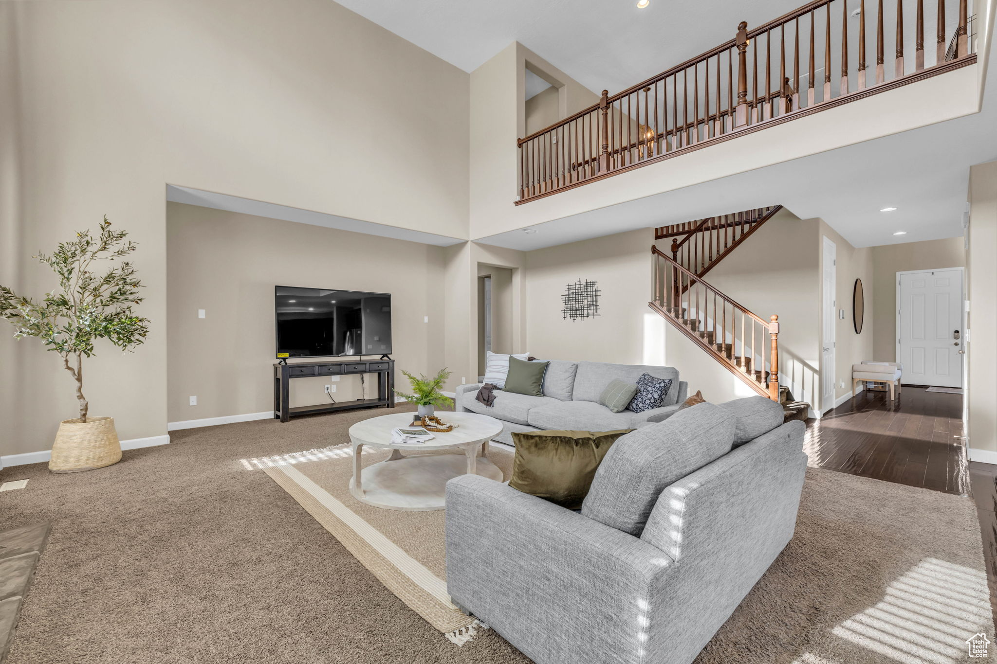 Living room with hardwood / wood-style floors and a high ceiling