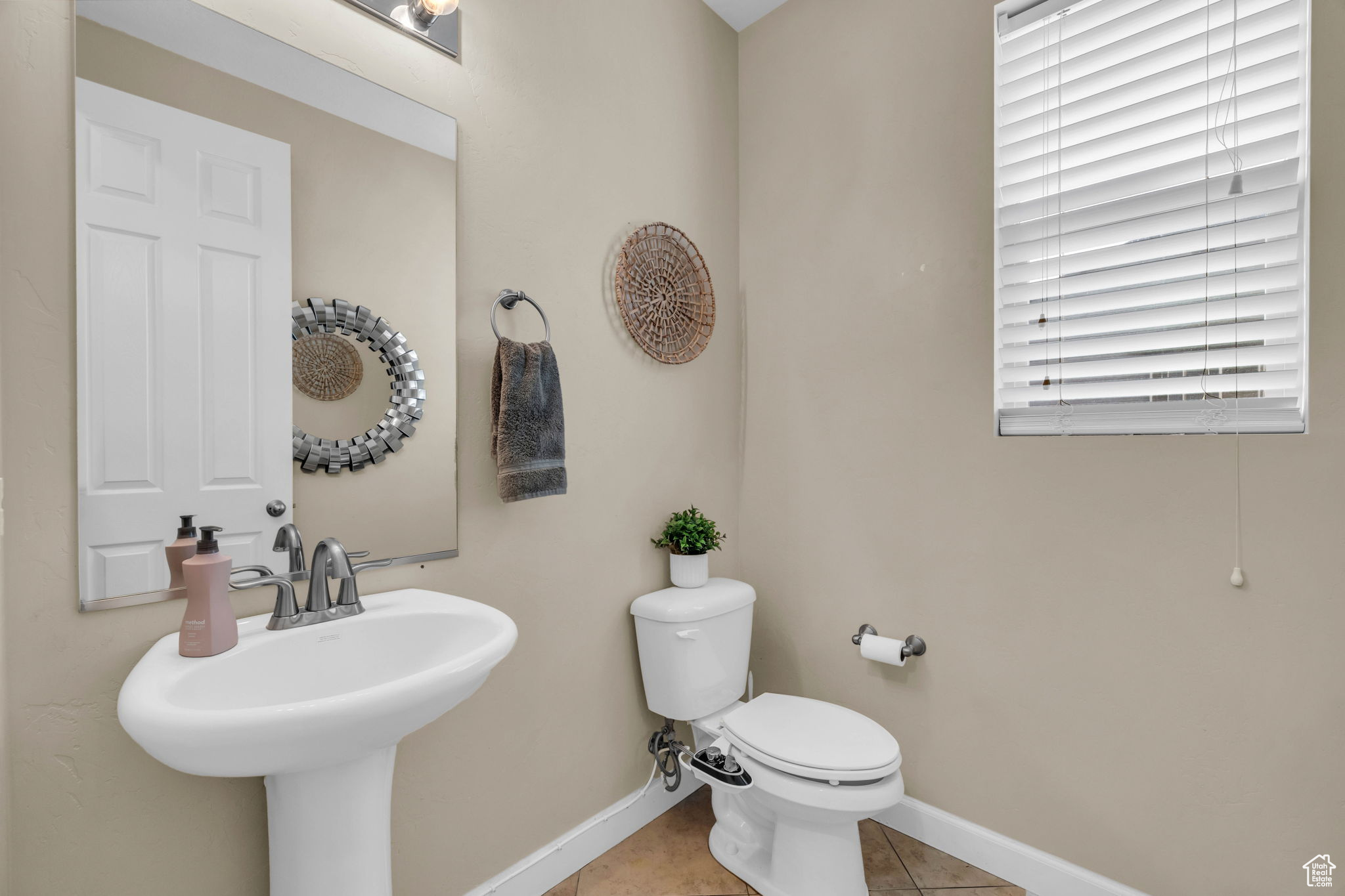 Bathroom with tile patterned flooring, toilet, a healthy amount of sunlight, and sink