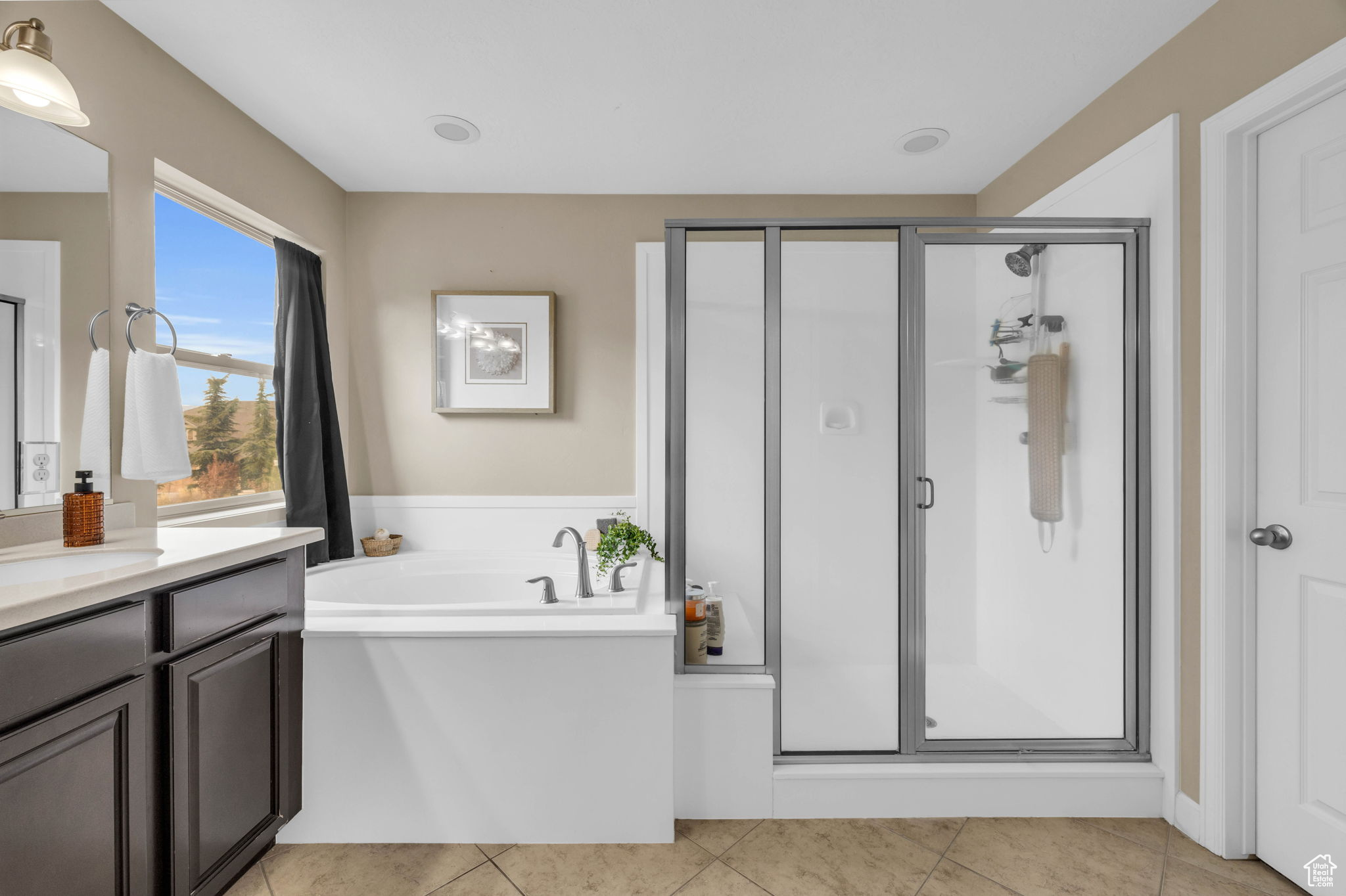 Bathroom with tile patterned flooring, vanity, and separate shower and tub