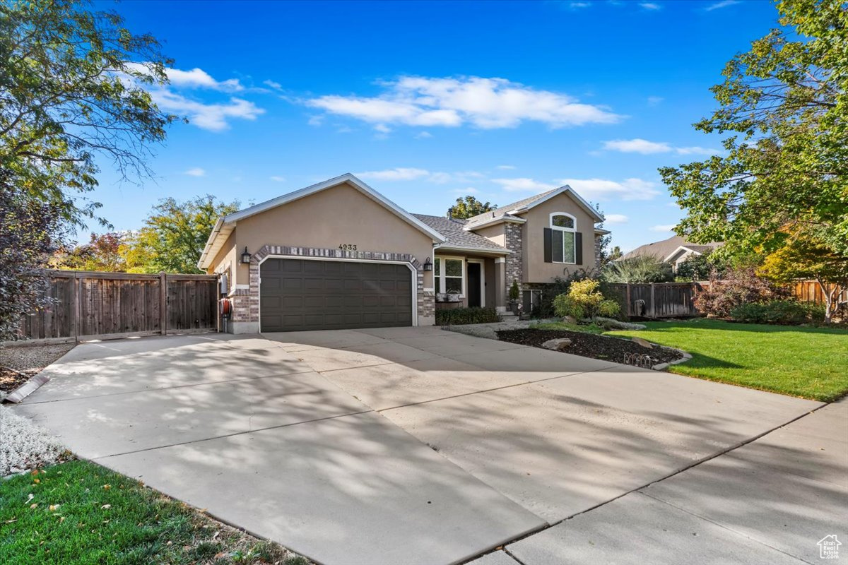 View of front of house featuring a front lawn and a garage