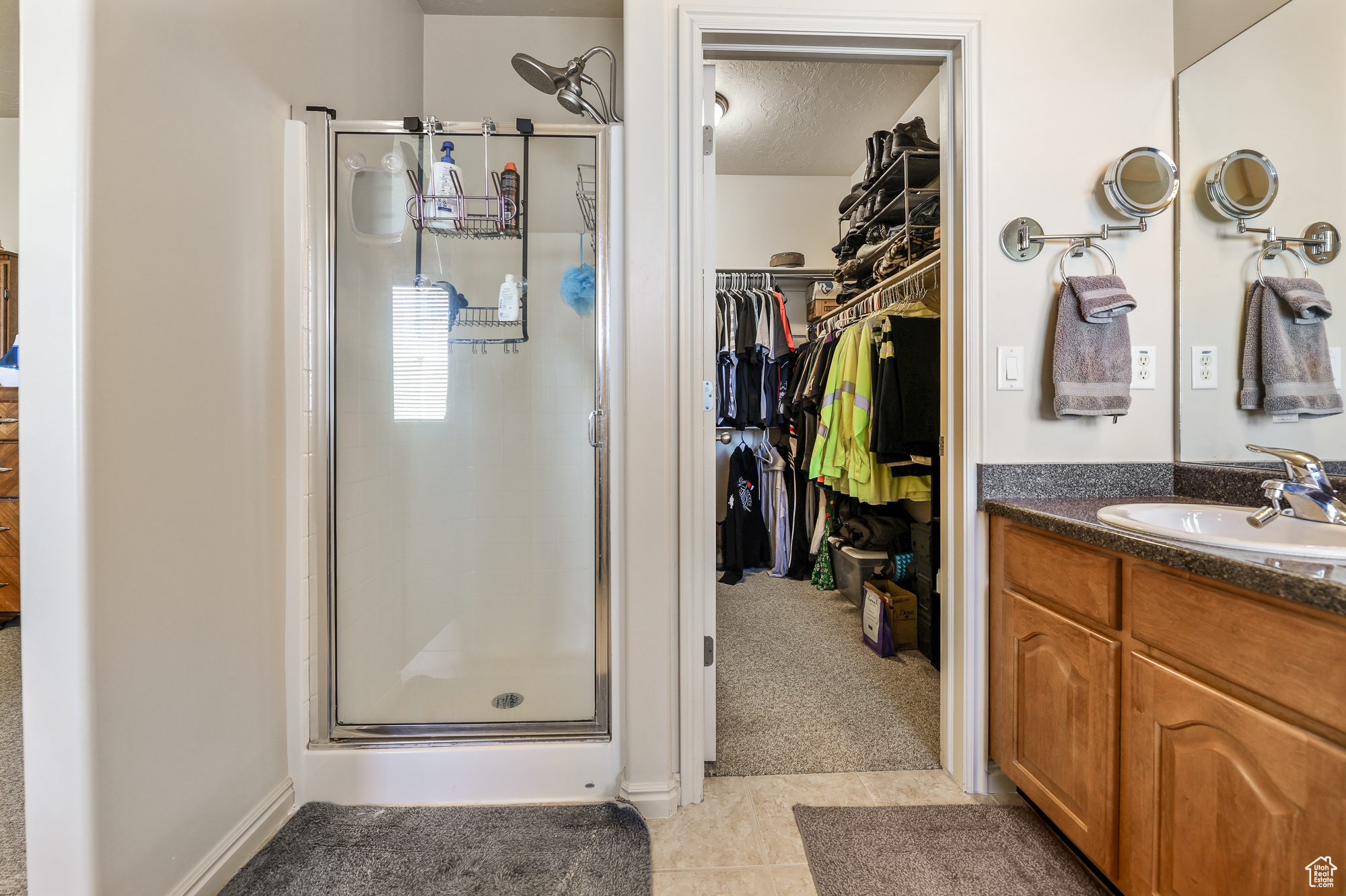 Bathroom with vanity, tile patterned floors, a textured ceiling, and walk in shower