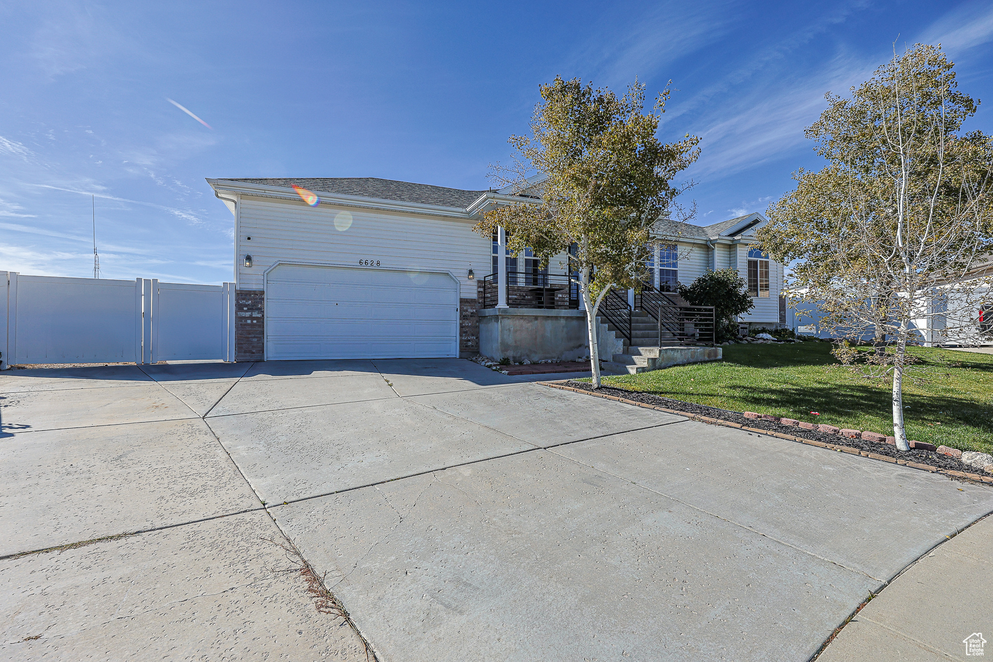 Ranch-style home featuring a front lawn and a garage