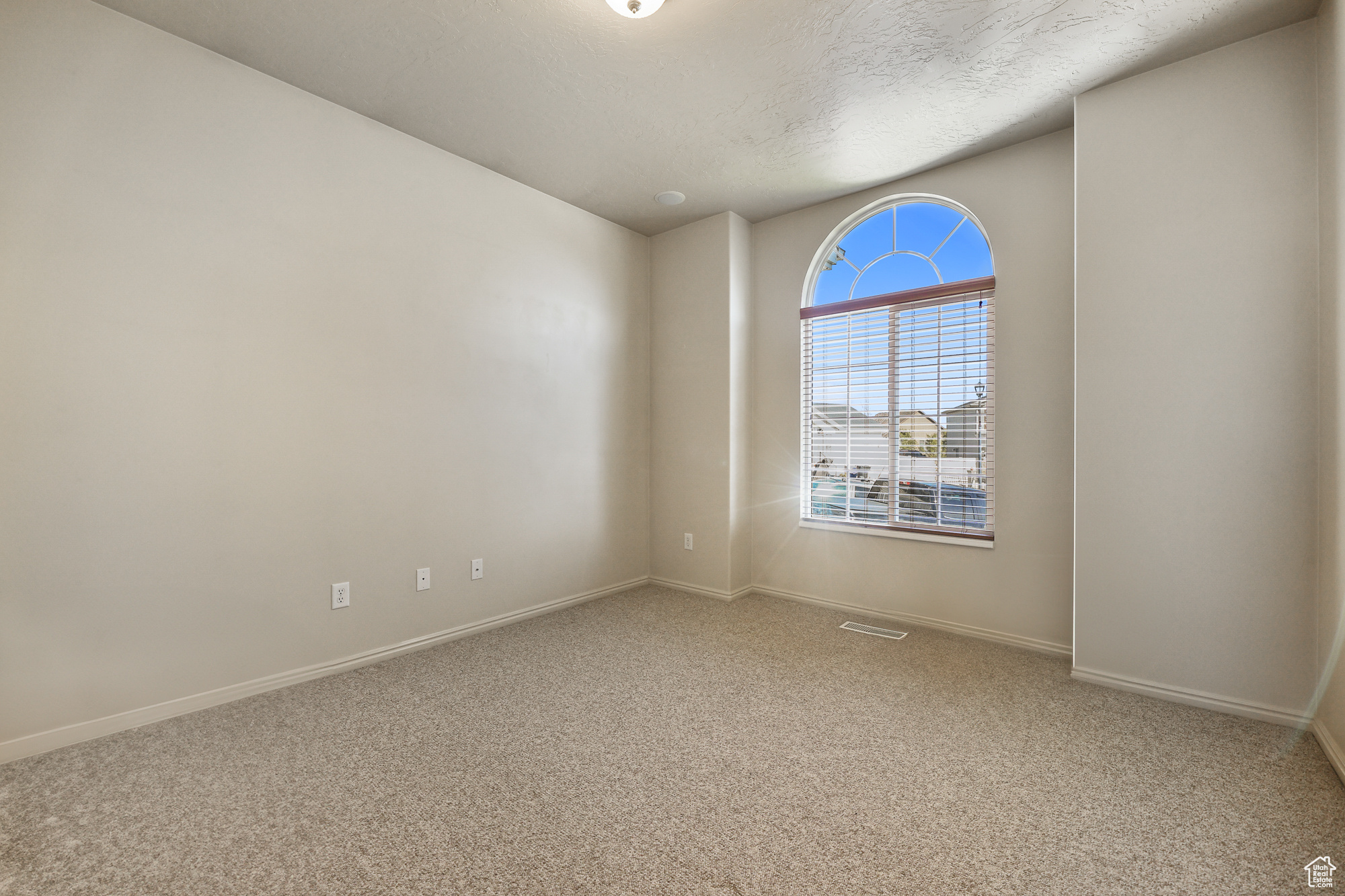 Carpeted spare room with a textured ceiling