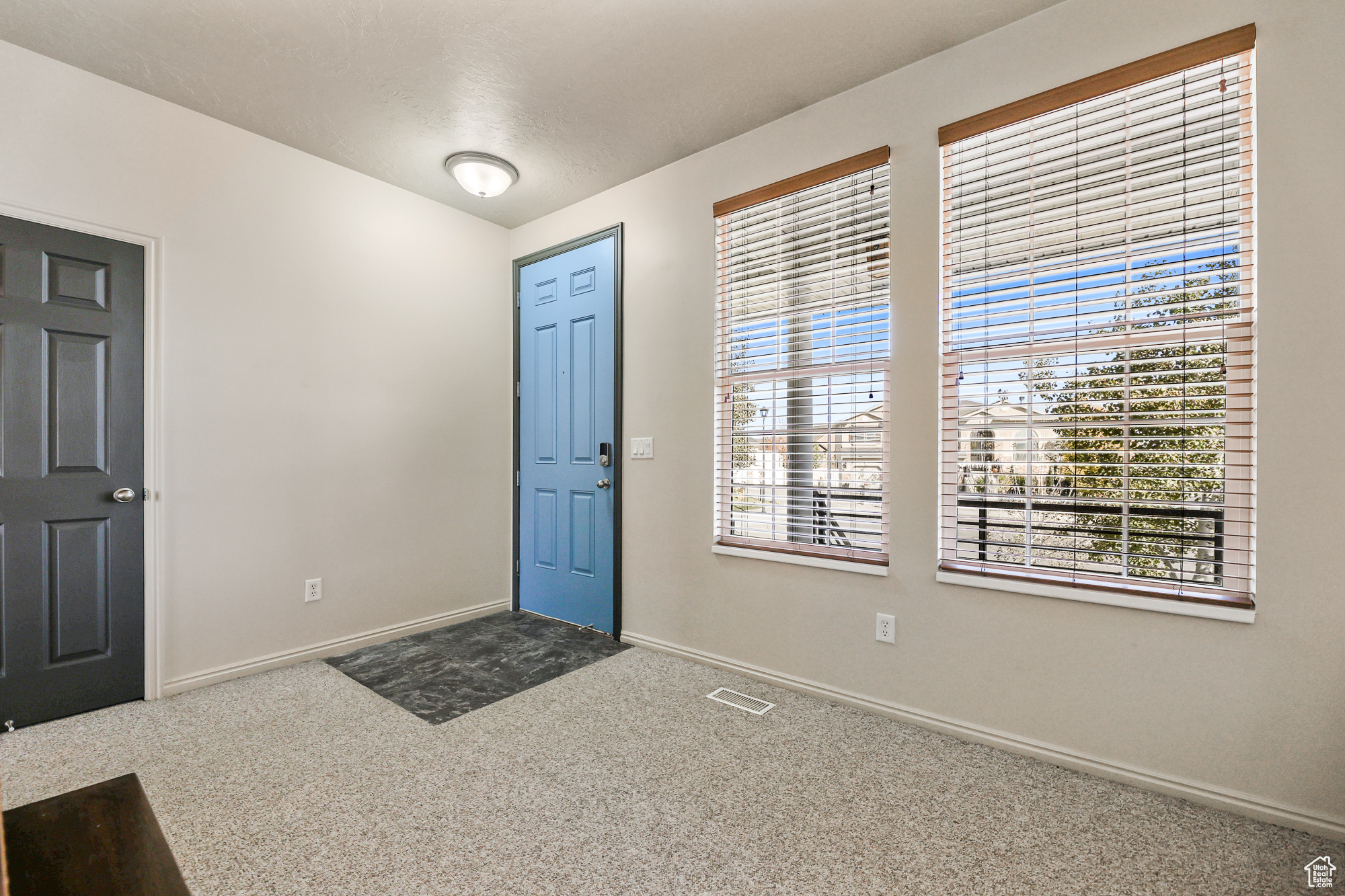 Carpeted foyer featuring a textured ceiling