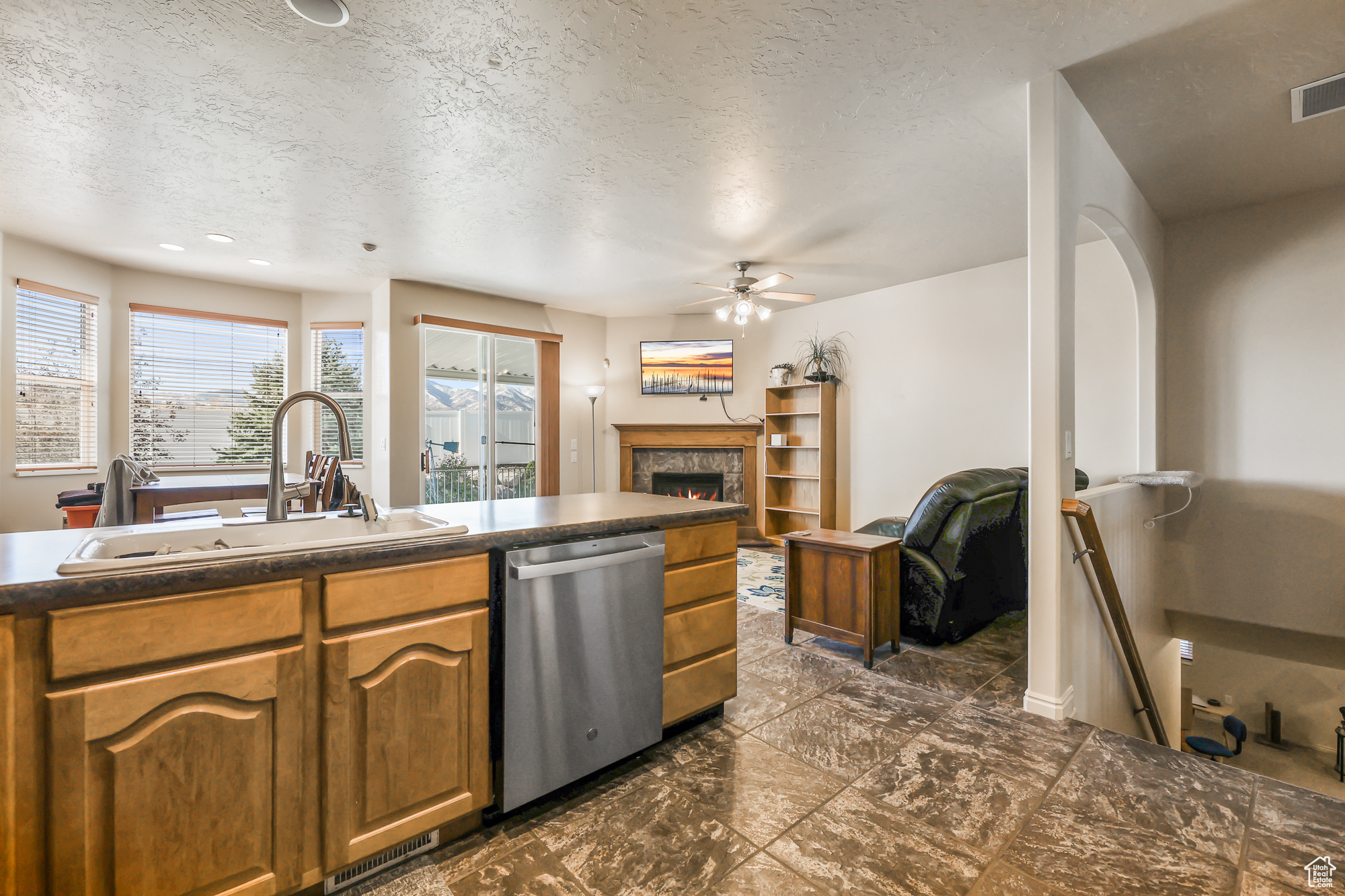 Kitchen with sink, dishwasher, a textured ceiling, and ceiling fan