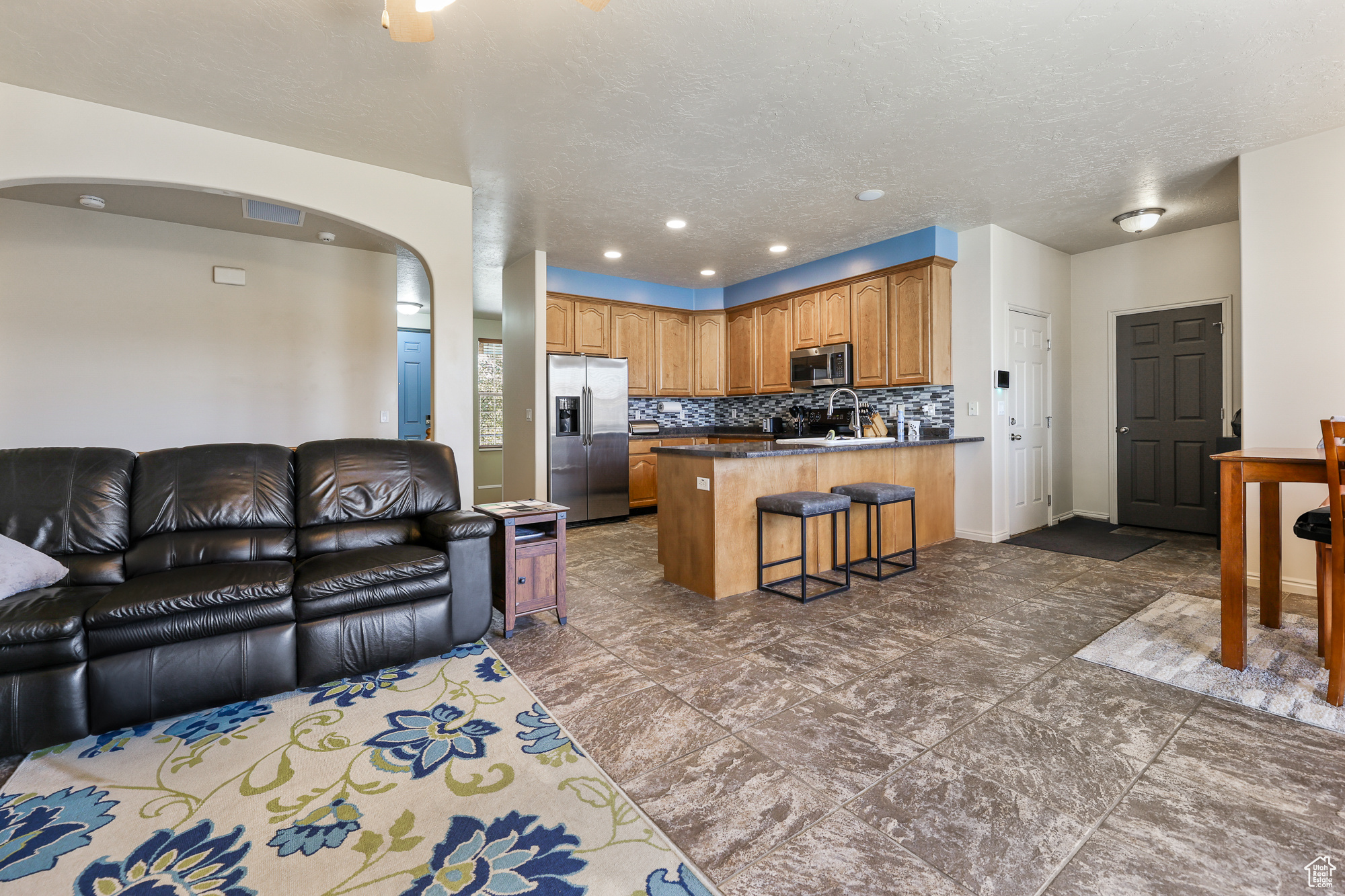 Living room with dark tile patterned flooring, a textured ceiling, and sink