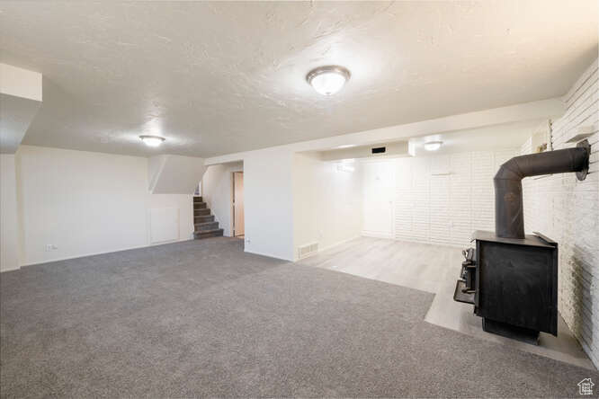 Basement featuring carpet floors and a wood stove