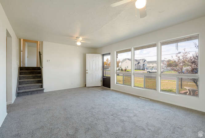 Living room featuring carpet flooring and ceiling fan