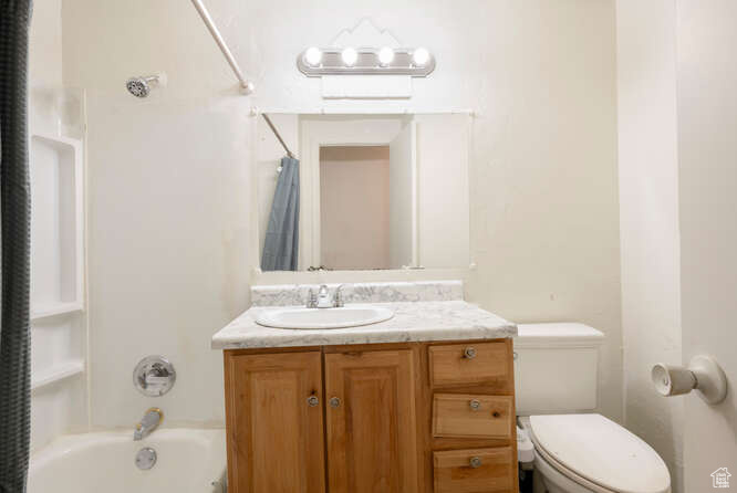 Full bathroom with vanity, toilet, and shower / bathtub combination with curtain