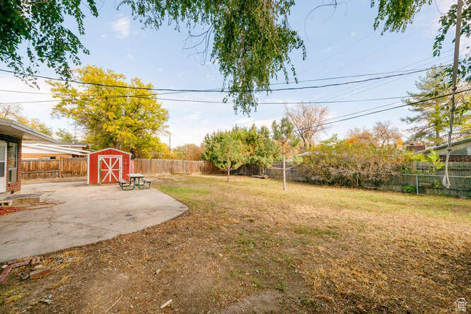 View of yard featuring a patio area and a storage unit