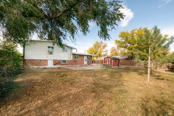 View of yard with a patio and a storage shed