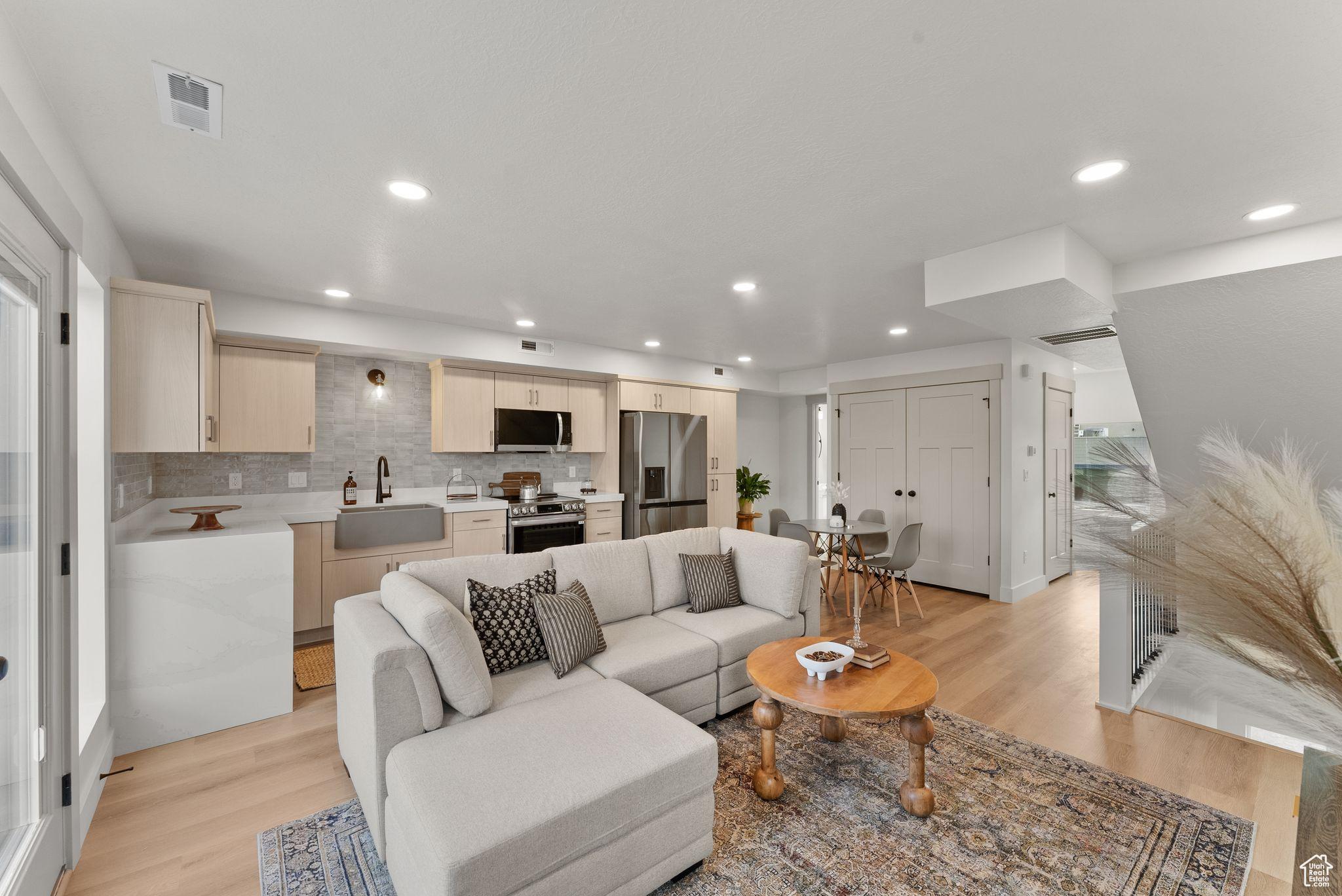 Living room with light hardwood / wood-style flooring and sink