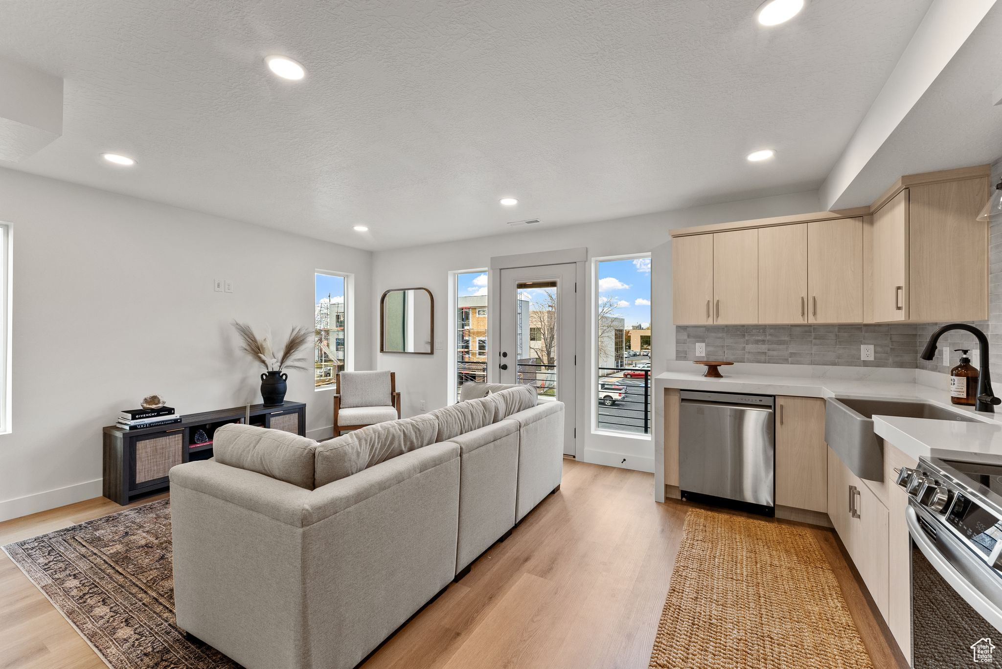 Kitchen featuring decorative backsplash, light wood-type flooring, stainless steel appliances, and sink