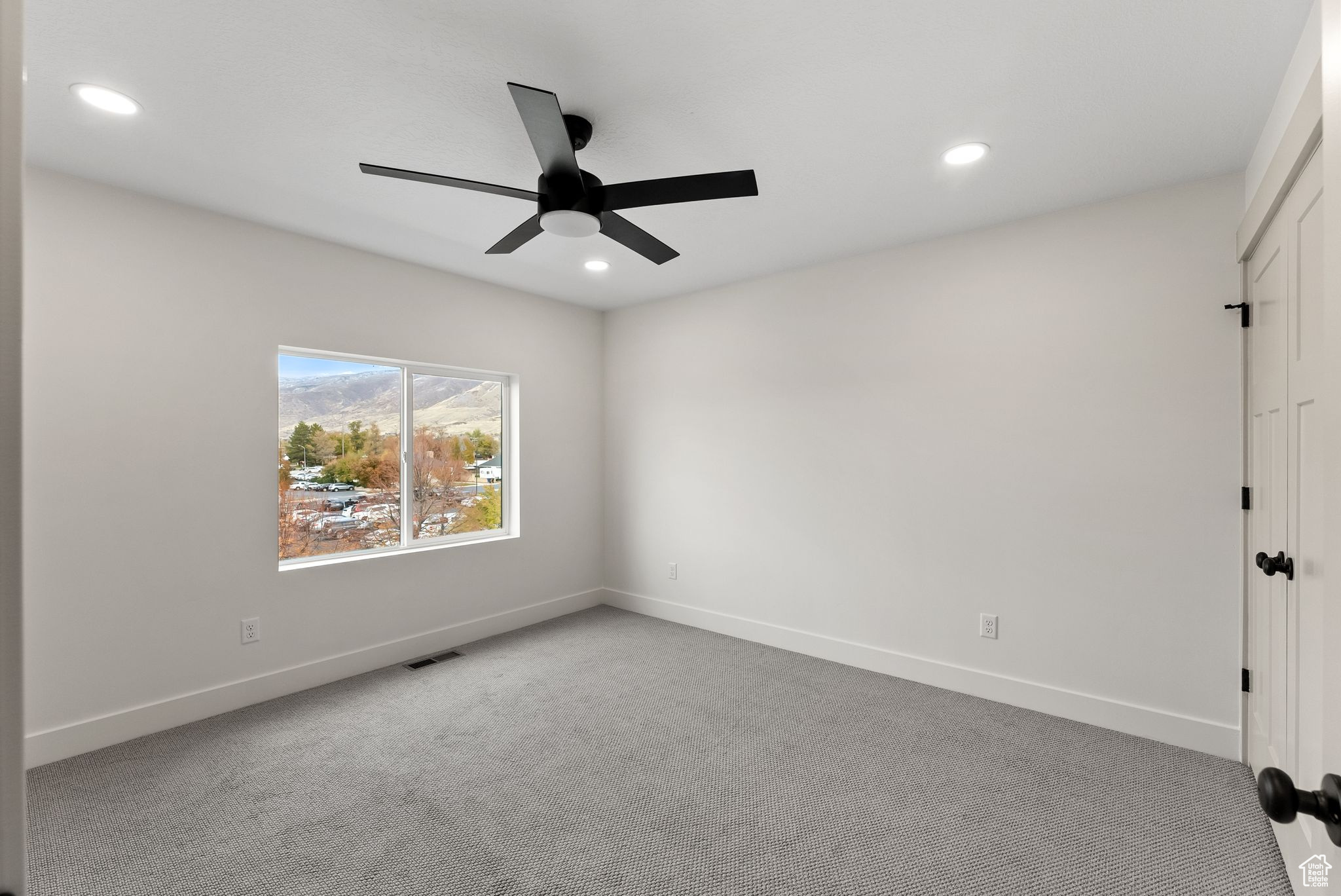 Unfurnished room with ceiling fan and light colored carpet