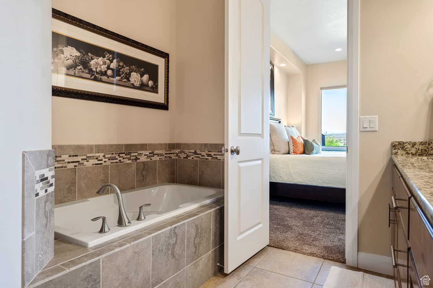 Bathroom with vanity, tiled bath, and tile patterned floors