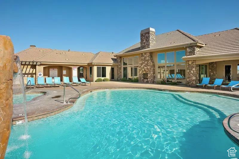 View of swimming pool with pool water feature and a patio