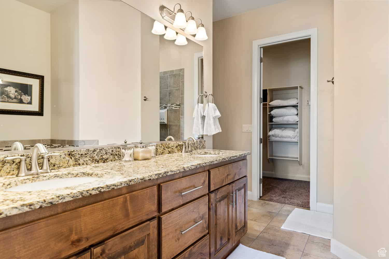 Bathroom featuring walk in shower, vanity, and tile patterned flooring