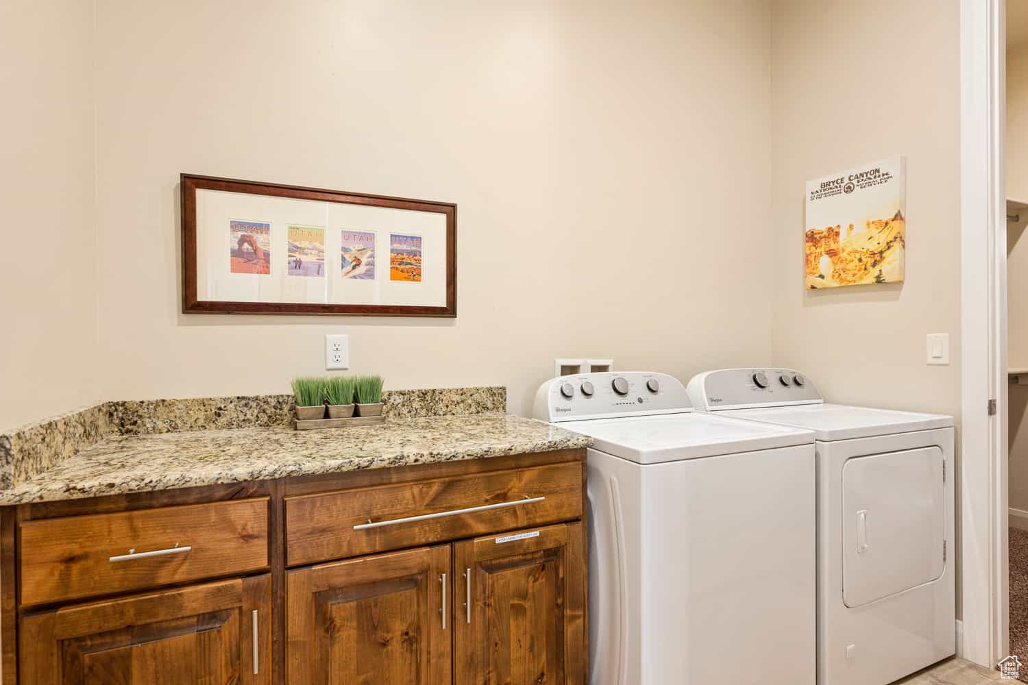 Clothes washing area featuring cabinets and washing machine and clothes dryer