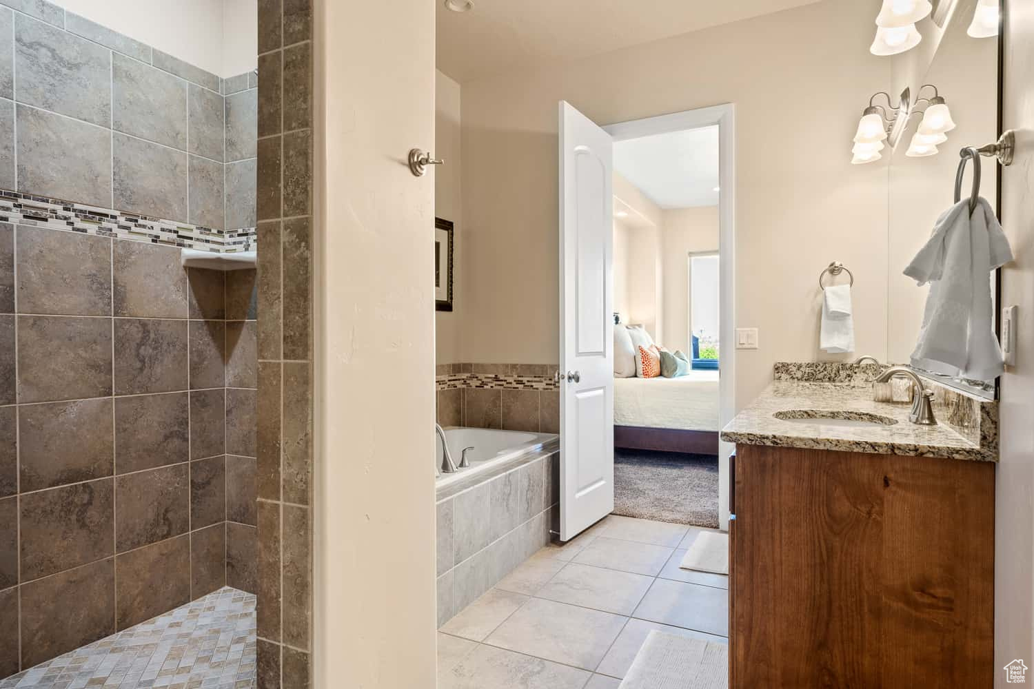 Bathroom with vanity, a relaxing tiled tub, and tile patterned floors