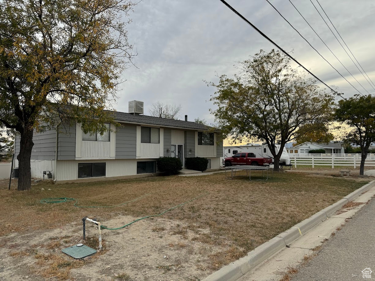 Raised ranch with central air condition unit and fence