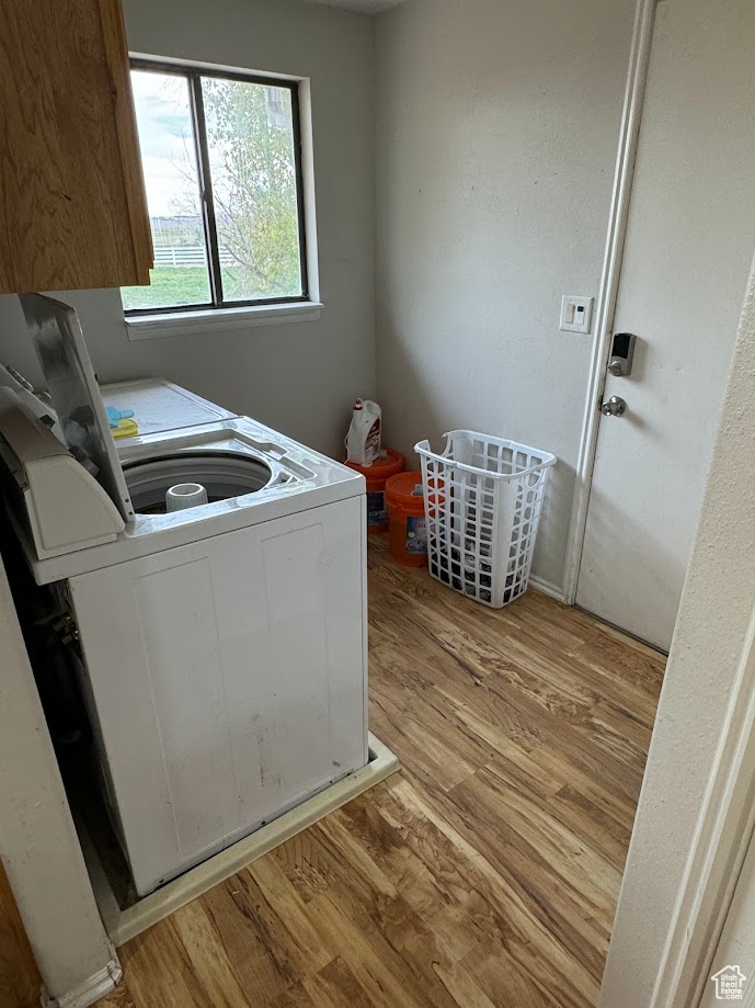 Clothes washing area featuring light wood-style flooring