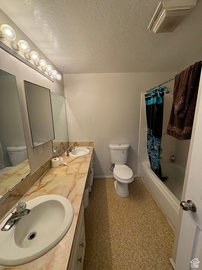 Bathroom with a sink, toilet, shower / tub combo with curtain, and double vanity