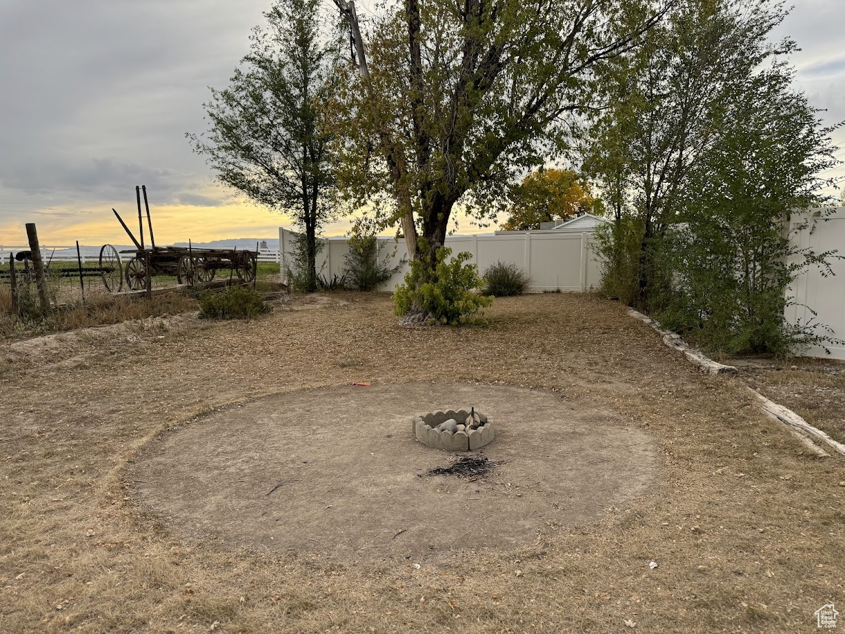 View of yard with a fire pit and fence