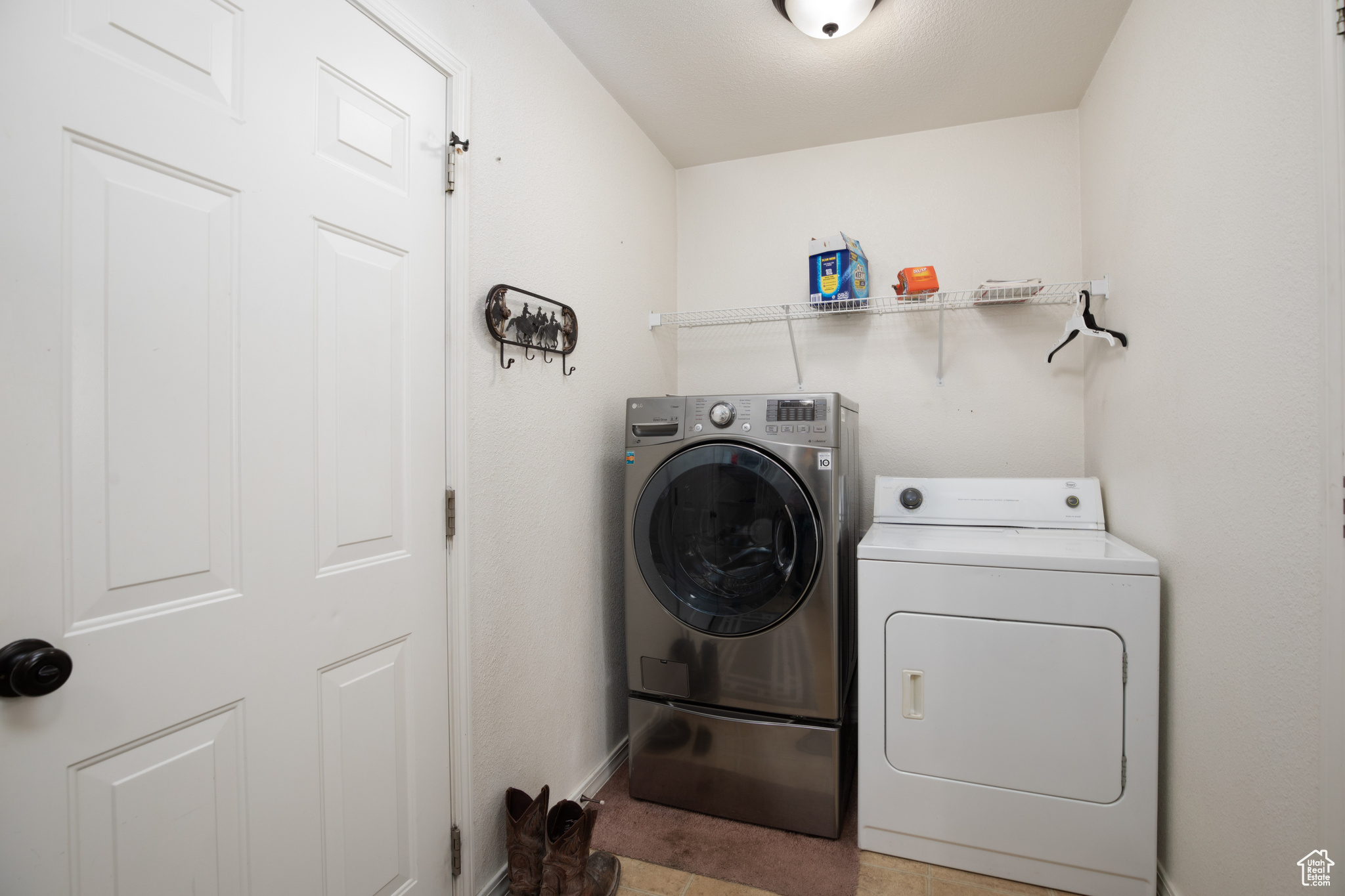 Washroom featuring light tile patterned flooring and independent washer and dryer