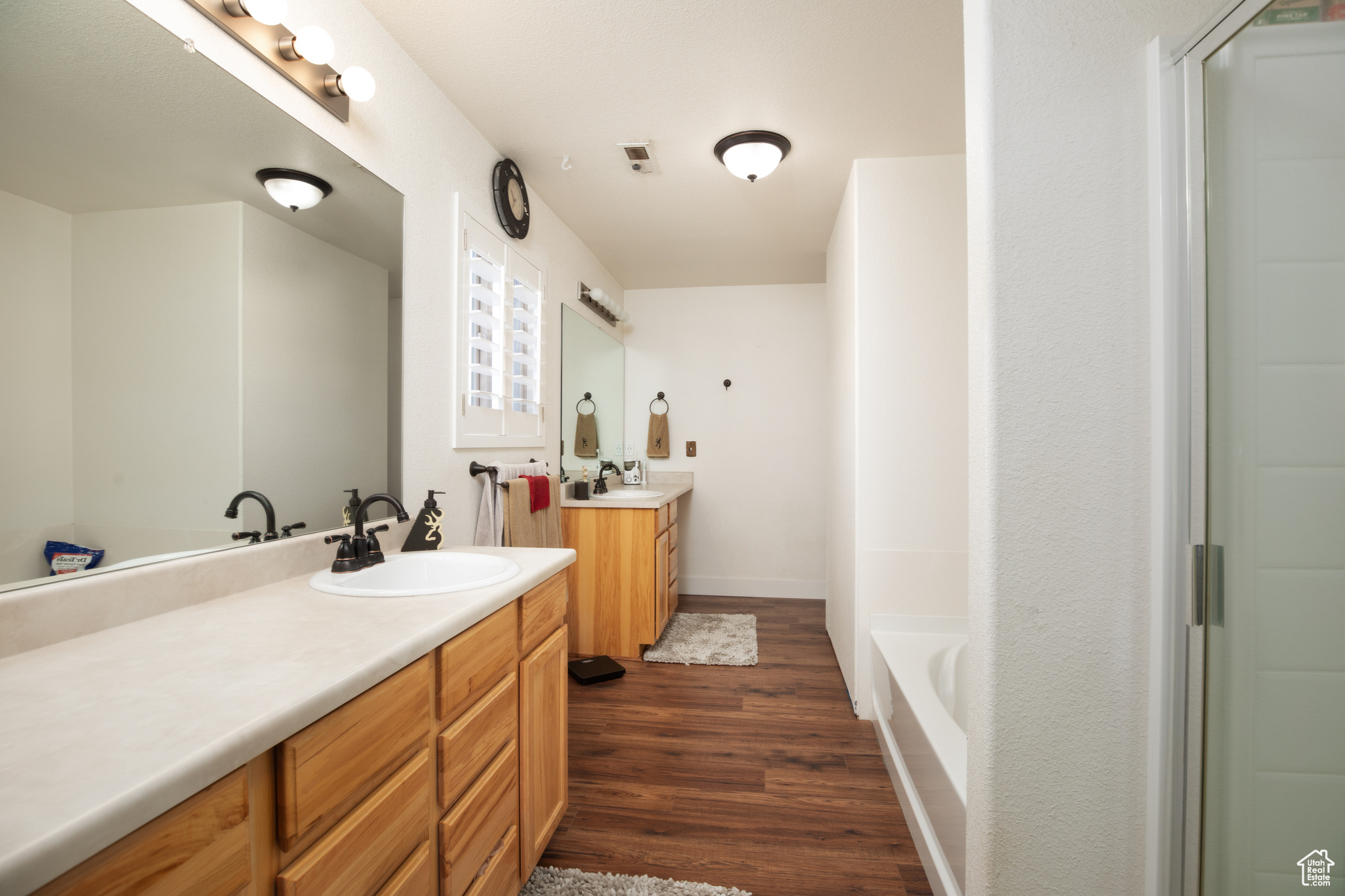 Bathroom with wood-type flooring, vanity, and a bathing tub