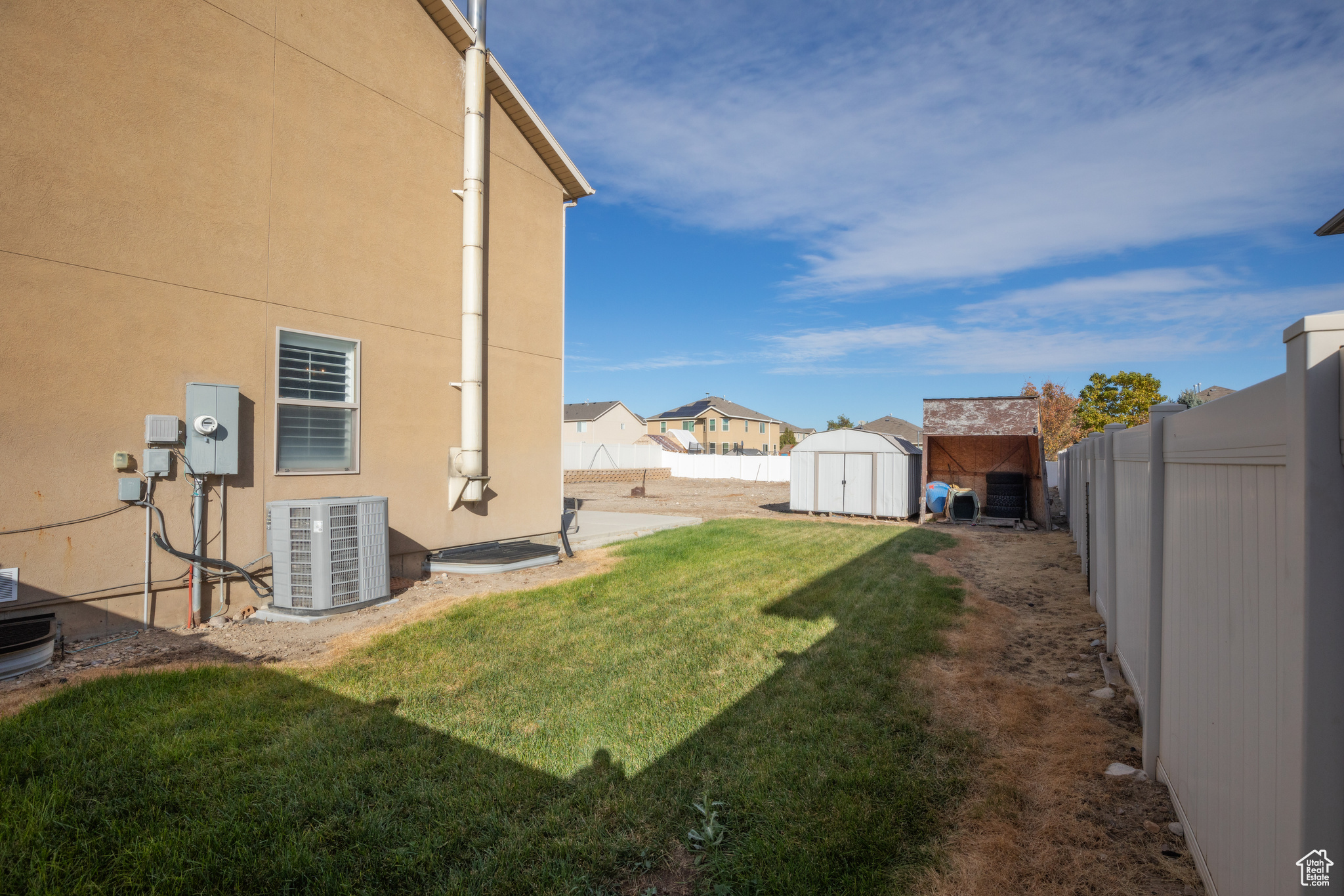 View of yard featuring a storage unit and central AC