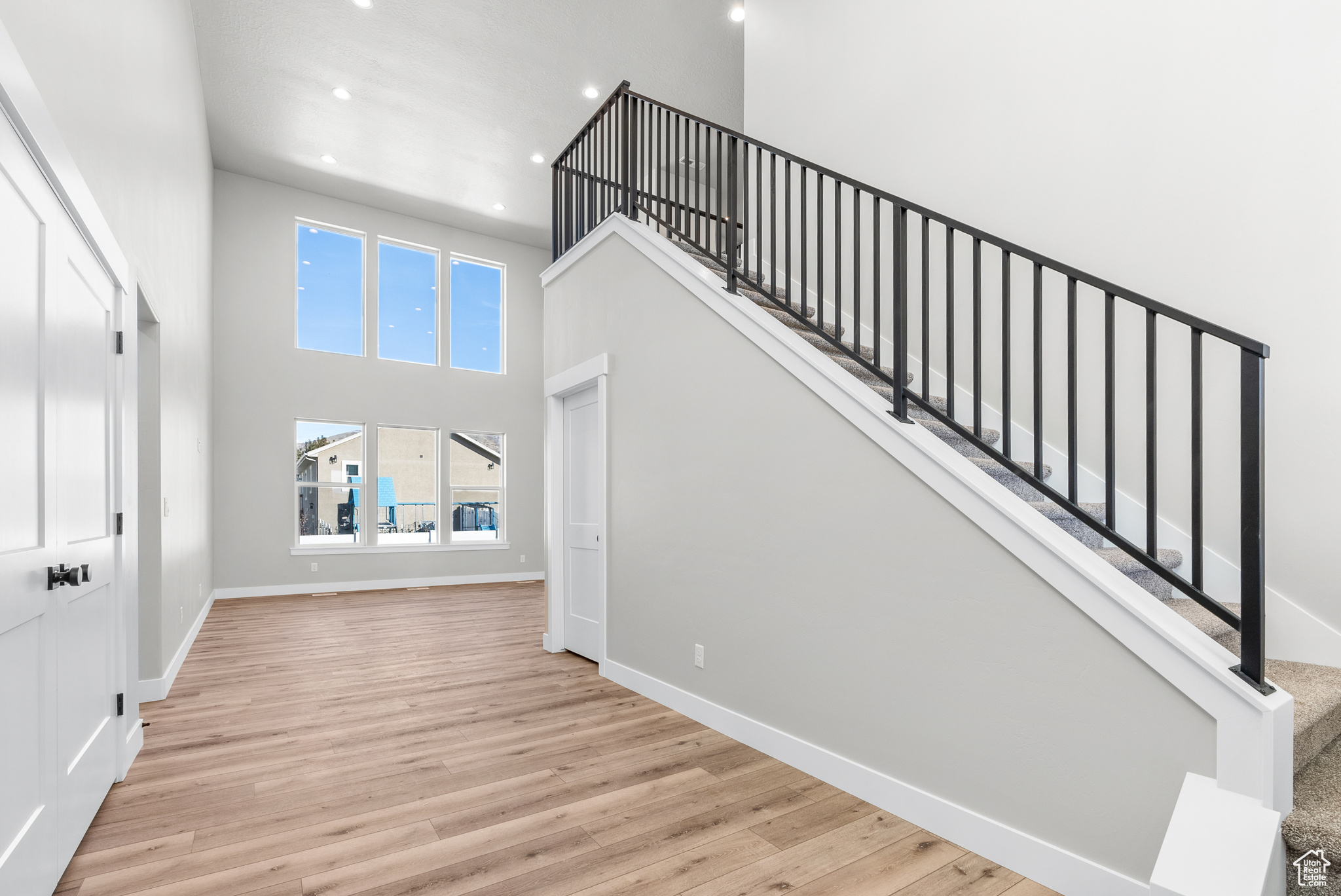 Stairs featuring a towering ceiling and hardwood / wood-style flooring