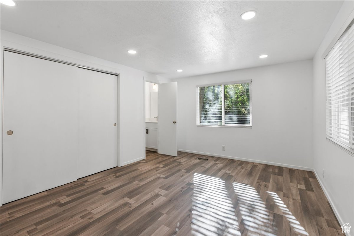 Primary Suite bedroom featuring dark wood-type flooring and a closet