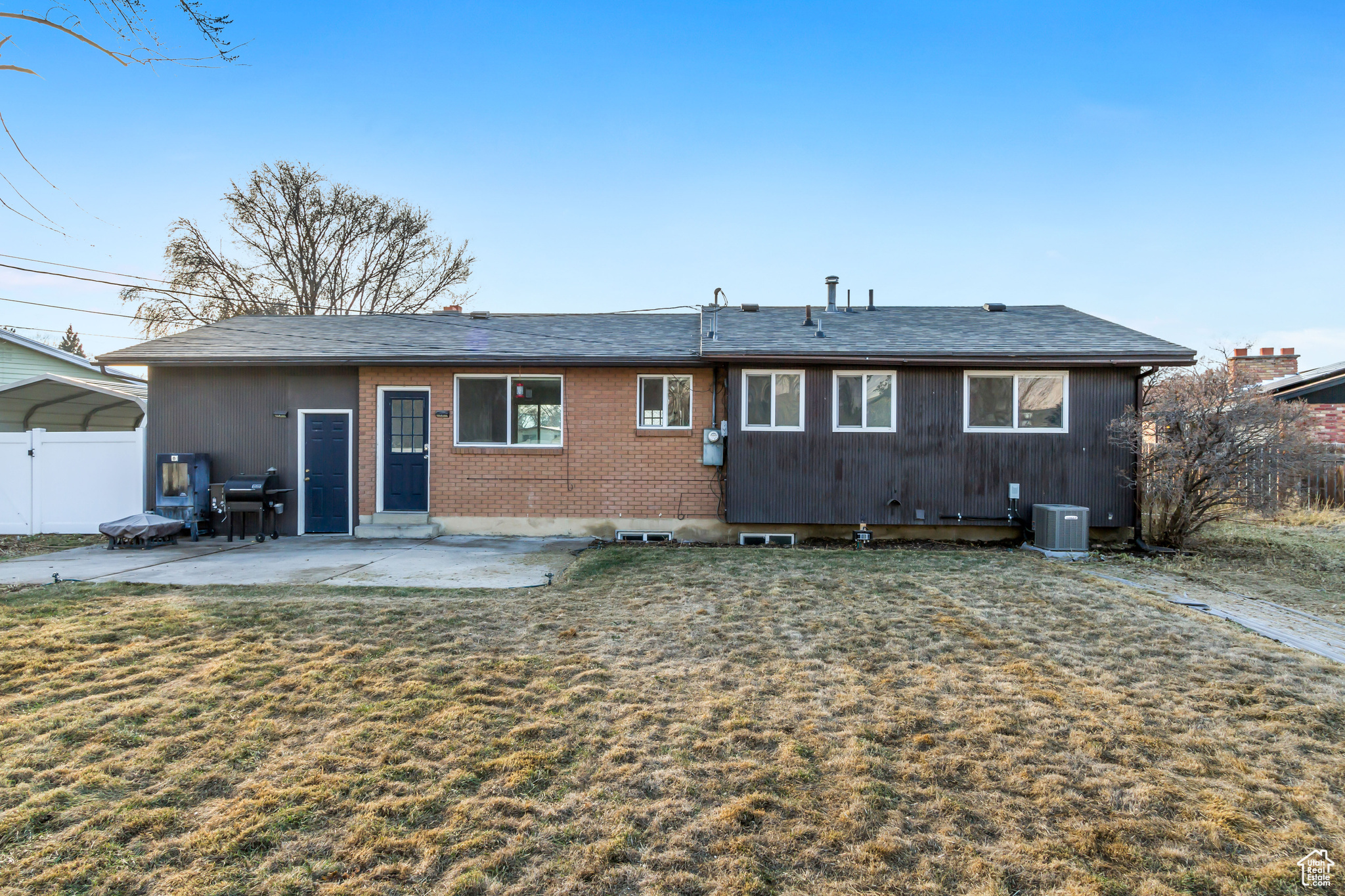 Back of property with a lawn, central AC, and a patio