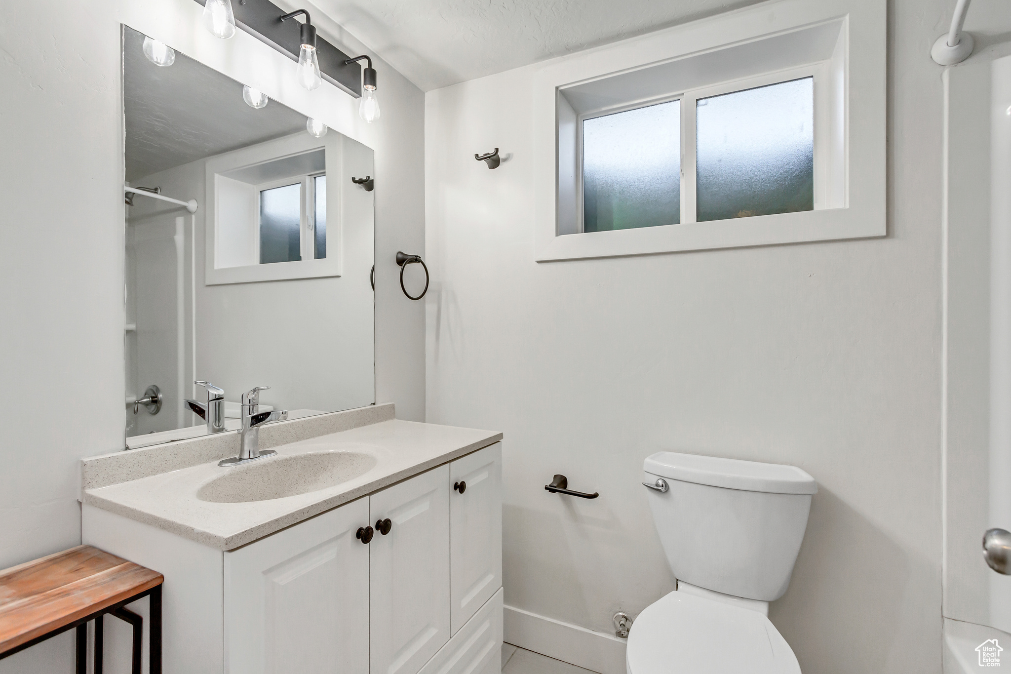 Bathroom featuring vanity, a shower, toilet, and a textured ceiling