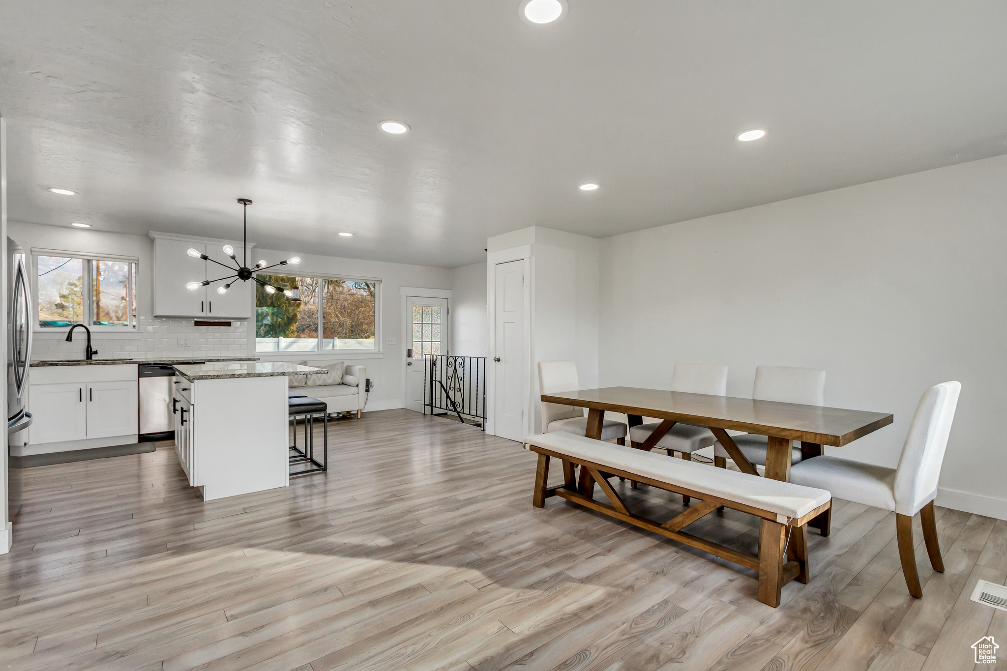 Dining space with a chandelier, light wood-type flooring, and sink