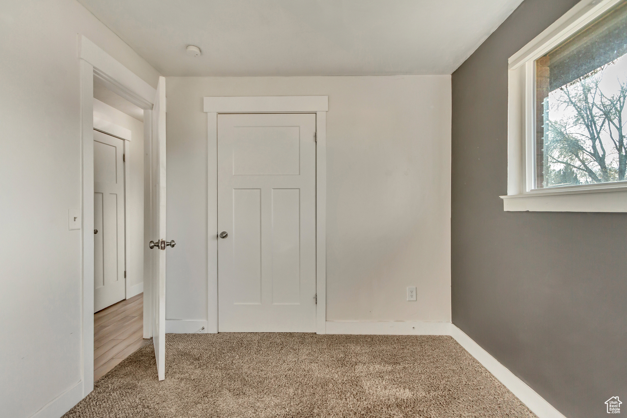 Unfurnished bedroom with light colored carpet